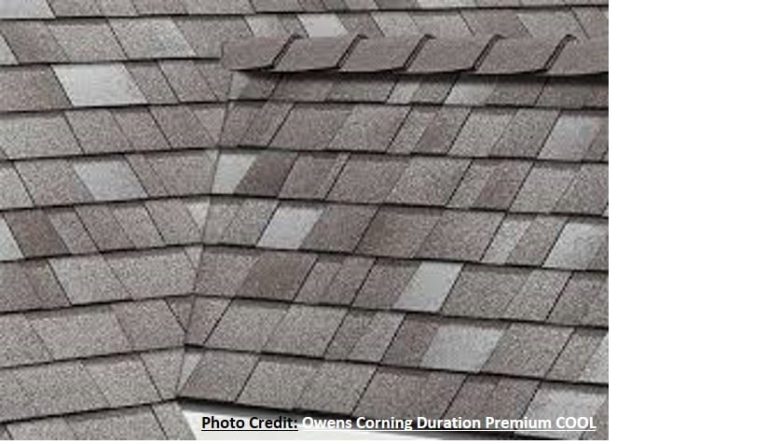 A close-up of gray textured shingles along a roof ridge and hip, showing overlapping layered detail.