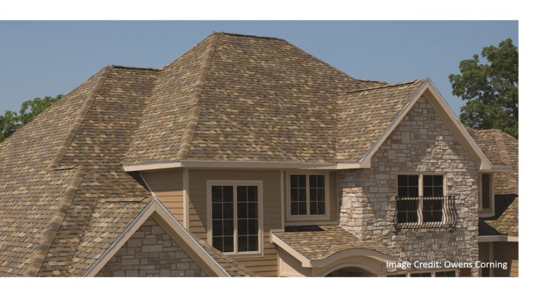 Close-up of a stone and siding home with a warm tan, multi-tone blended architectural shingle roof and multiple gables.