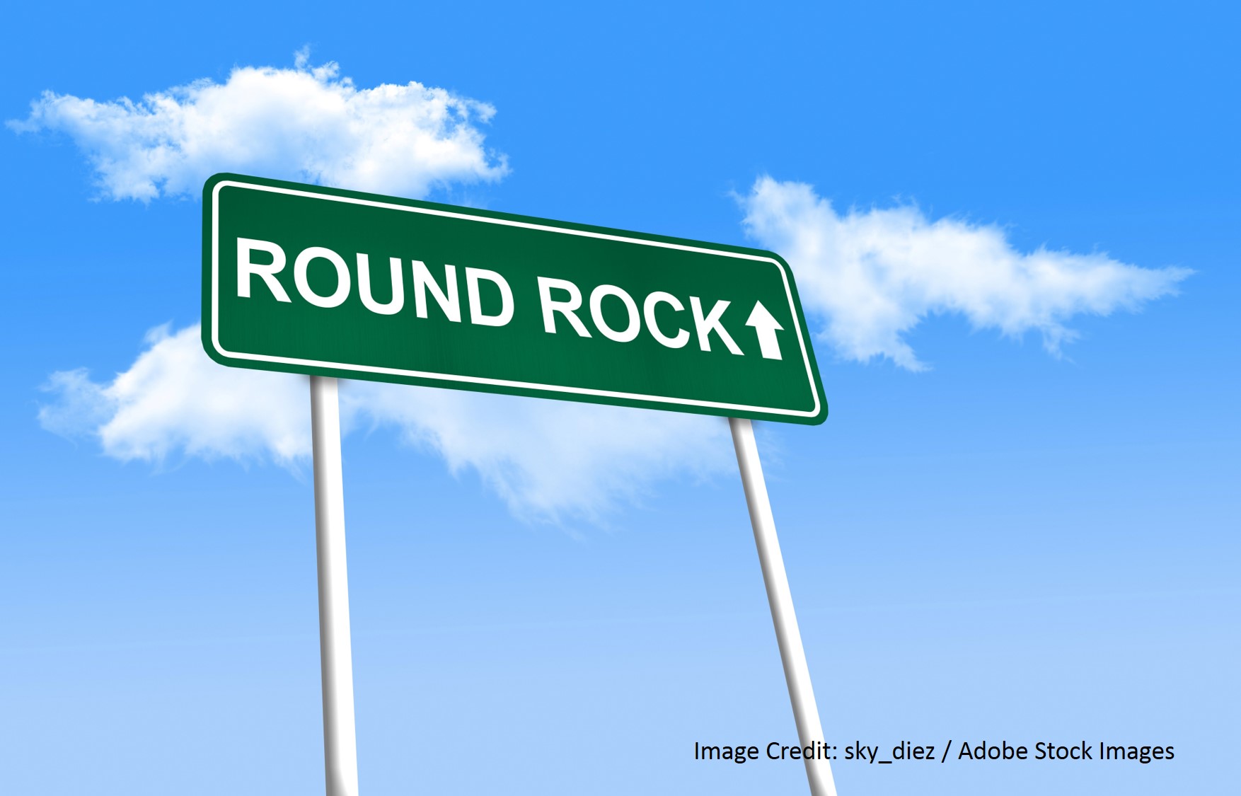 A green Round Rock road sign against a blue sky.