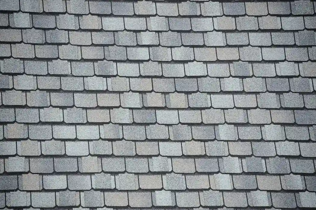 Close-up of gray and charcoal architectural shingles arranged in overlapping dimensional rows on a residential roof in Austin, TX.